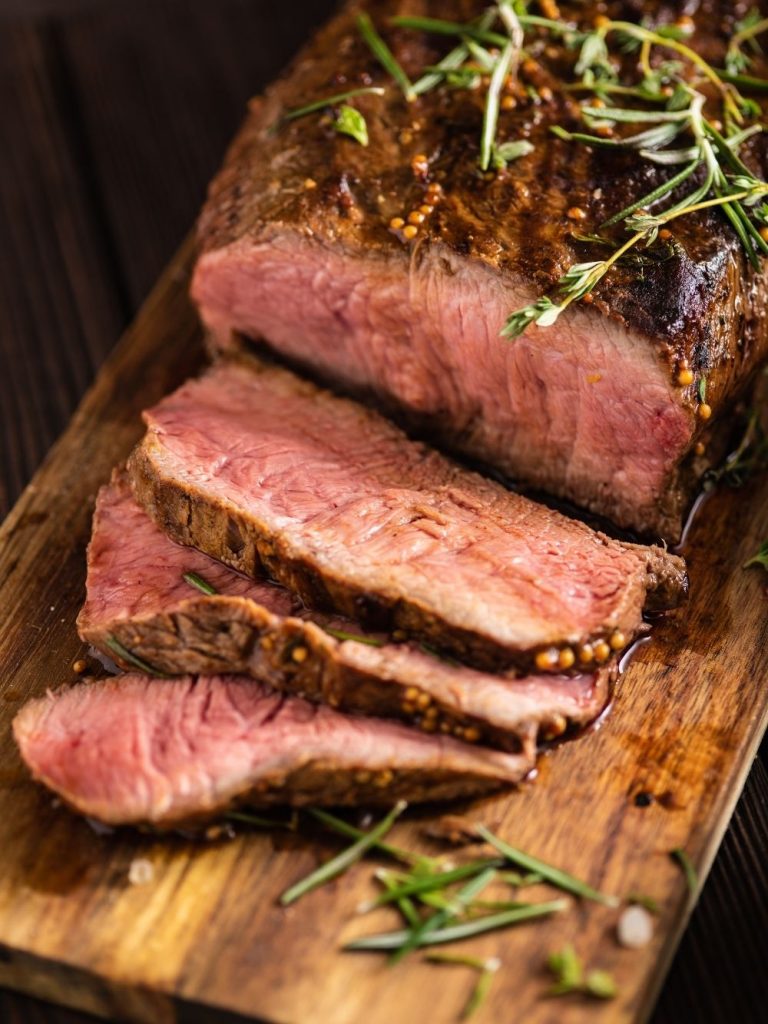 Sliced and Dressed Roast Beef on Cutting Board