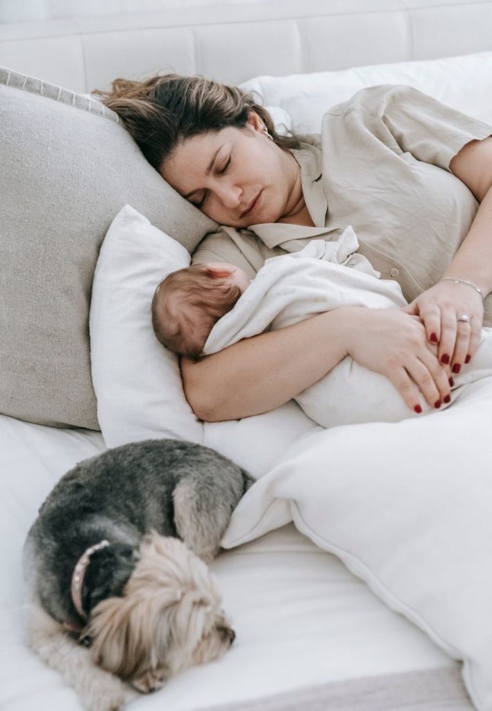 Woman with Baby and Dog Sleeping on Bed